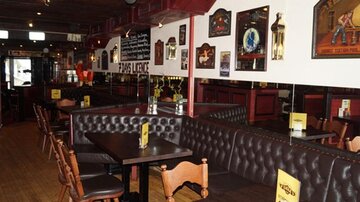 Ein gemütliches Restaurant mit Lederbänken und Holztischen. Die Wände sind mit Dekorationen und Bildern geschmückt.