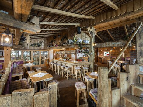 Ein gemütliches Restaurant mit Holzmöbeln und rustikalem Ambiente. Die warme Atmosphäre lädt zum Verweilen und Speisen ein.