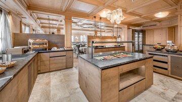 Ein modernes Restaurant mit Holzverkleidung und eleganter Beleuchtung. Die Buffets sind stilvoll eingerichtet und bieten eine Vielzahl von Speisen an.