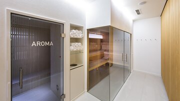Ein modernes Wellnessbereich mit einer Aroma-Dusche und einer Glas-Sauna. Gepflegte Handtücher liegen bereit, und die Wände sind in sanften, natürlichen Farben gehalten. | © Rössle
