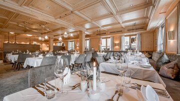 Ein elegantes Restaurant mit stilvollen Tischen und modernen Möbeln. Sanftes Licht schafft eine einladende Atmosphäre.