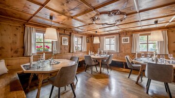 Ein gemütliches Restaurant mit Holzverkleidung und warmem Licht. Die Tische sind schön gedeckt und bieten Platz für mehrere Gäste. | © Rössle