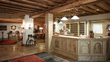 An inviting reception area with warm wood and gentle lighting. The space is comfortably and stylishly furnished, perfect for a relaxing atmosphere.