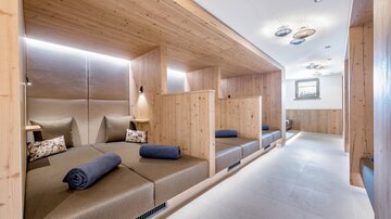 A relaxing quiet room with wood paneling and comfortable loungers. Each area is separated by walls, creating a tranquil atmosphere.